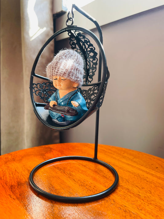 Baby Monk Buddha with Woollen cap on a Swing